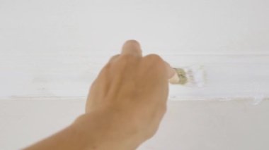 the hand of the master paints the plinth white with small brush. High quality FullHD footage