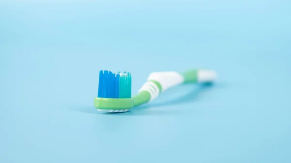 toothpaste and brush on a blue background, oral and dental care concept.