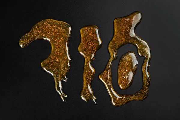 710 Lettering Golden Cannabis Wax Resin Dark Background ストック写真