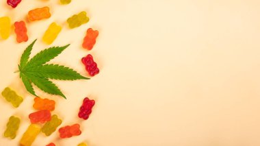 cannabis jelly candy and green leaf with copy space.