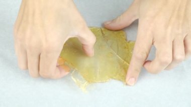 smoker breaks golden cannabis extract wax with his hands. High quality FullHD footage