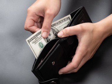 get money from the wallet on a dark background, 100 dollar banknote.
