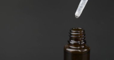 pipette cannabis oil extract drop dripping in bottle copy space on dark background High quality 4k footage