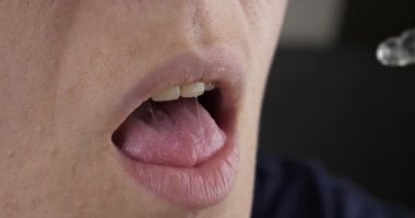 woman taking medicine cannabis oil, drip drops from a pipette into the mouth High quality 4k footage