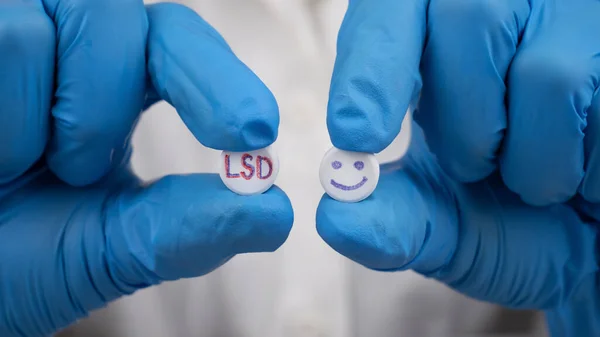 blue and red LSD pills in doctor hands, psychedelic drug for the treatment of severe stages of depression.