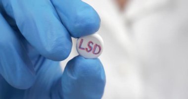 psychedelic lsd tablet in the hands of a medic. High quality 4k footage