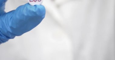  LSD pill in doctor hands, psychedelic drug for the treatment of severe stages of depression. High quality 4k footage