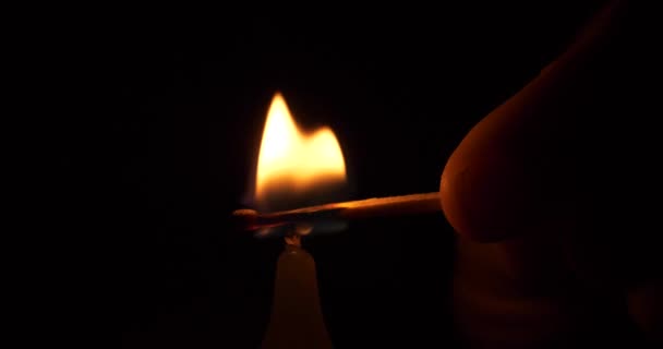 Hand Zündet Eine Kerze Mit Einem Streichholz Dunkeln Hochwertiges Filmmaterial — Stockvideo