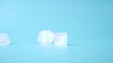 Düşen buz küpleri mavi arka planda, donmuş su içmek için yüksek kaliteli FullHD görüntüler