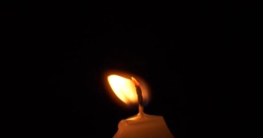 Karanlık arka planda rüzgarda yanan mum, keder ve ölülerin anıları. Yüksek kalite 4k görüntü
