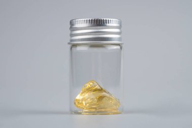 piace kenevir özü, gri arka planda şeffaf şişe kapağı olan balmumu çıkar.