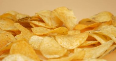 Parmaklar altın patates cipsini yakın plan, kızarmış tuzlu atıştırmalık alır. Yüksek kalite 4k görüntü