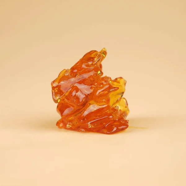 amber yellow piece of cannabis wax with high thc close up.