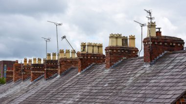 Clay chimney pots on the top of red brick chimney stack of a residential house