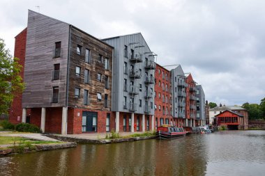 Chester, UK: Jul 3, 2022: A general scene of the Shropshire Union Canal in Chester, with canal boats moored outside a modern block of student accommodation