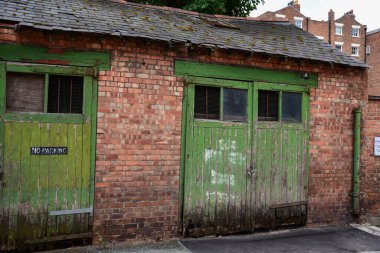 Rustic wooden doors in a red brick garage
