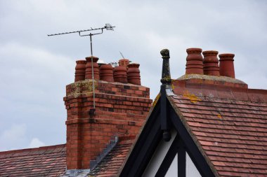 Clay chimney pots on the top of red brick chimney stack of a residential house