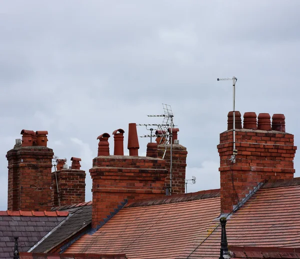 Clay chimney pots on the top of red brick chimney stack of a residential house