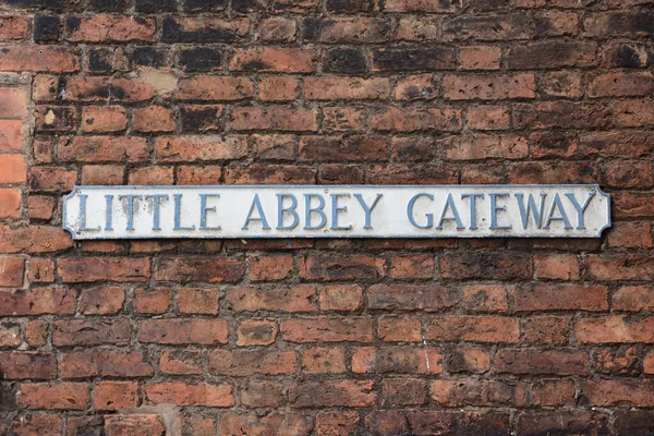 Faded Street Name Sign Little Abbey Gateway Mounted Red Brick — Stock fotografie