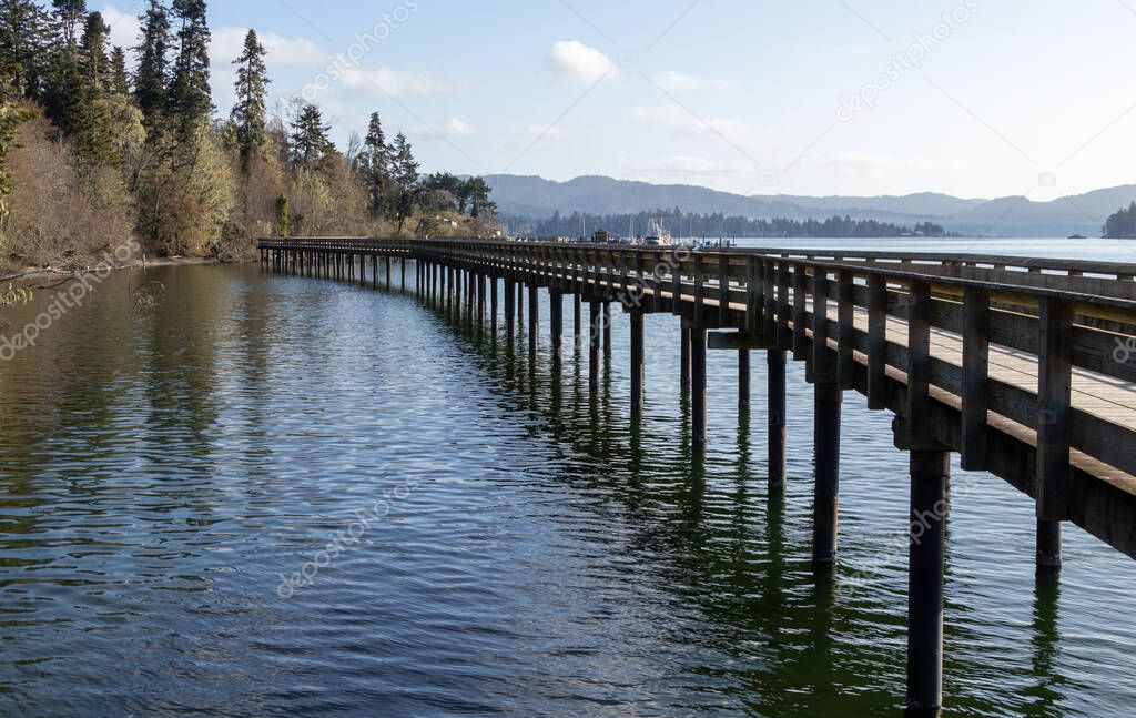 Boardwalk along the sea coast on a sunny day at Ed Macgregor Park in Sooke, British Columbia on Vancouver Island