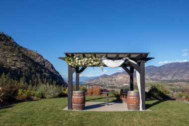 Okanagan Vadisi, British Columbia, Kanada 'daki bir şarap imalathanesinde yapılacak düğün için çiçeklerle süslenmiş bir pergola.