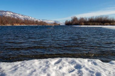 Kışın Okanagan Nehri Osoyoo, BC, Kanada 'da kar ve dağlarla çevrilidir.