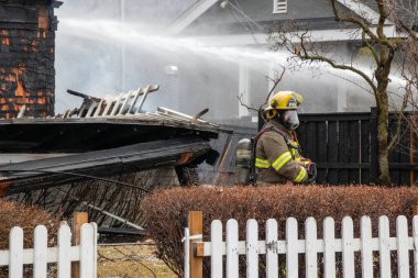 Penticton, BC, Kanada - 7 Mart 2022: Tarihi Warren House 'un önünde tam teçhizatlı itfaiyeci