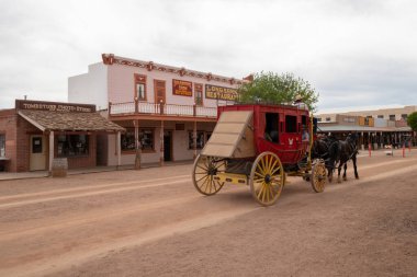 Tombstone, Arizona, USA - April 18, 2022: A horse carriage taking tourists on a tour down the main street in the old west town to Tombstone, Arizona.