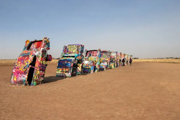 Amarillo, Texas, United States - May 2, 2022: graffiti covered cars buried nose first in the dirt at the famous roadside attraction of Cadillac Ranch on historic Route 66