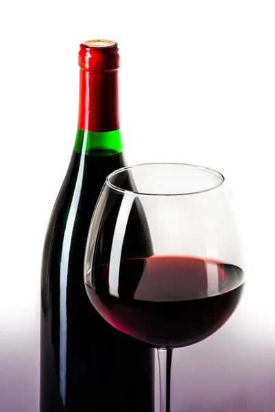 Şarap şişesi ve bir bardak şarap üzerine beyaz izole dolu — Stok fotoğraf