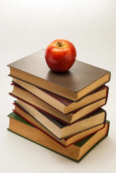 Stapelen van oude boeken met een appel op de top — Stockfoto