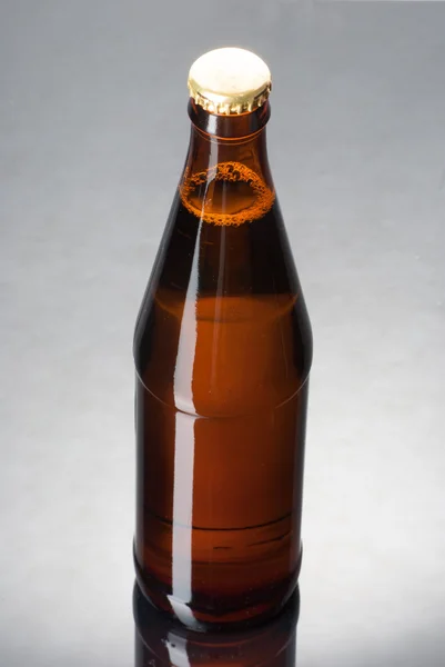 Sebotol bir di permukaan reflektif — Stok Foto