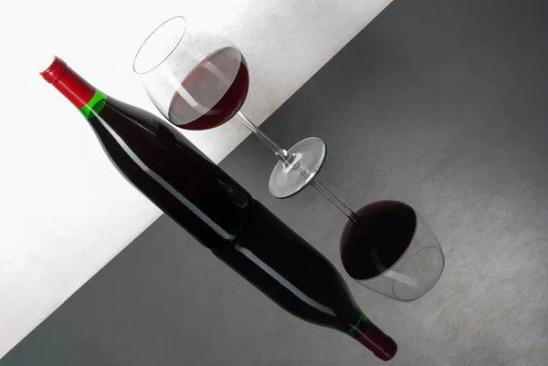 Wine bottle and a glass filled with wine on a black reflective s — Stock Photo, Image