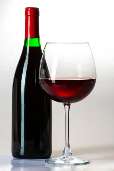 Wine bottle and a glass filled with wine isolated on white — Stock Photo, Image