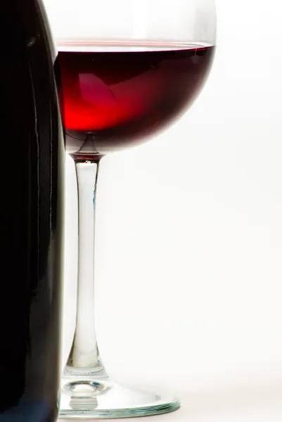 Пляшка вина і келих, наповнений вином ізольовані на білому — стокове фото