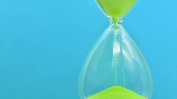 Detail of a green hourglass telling the time