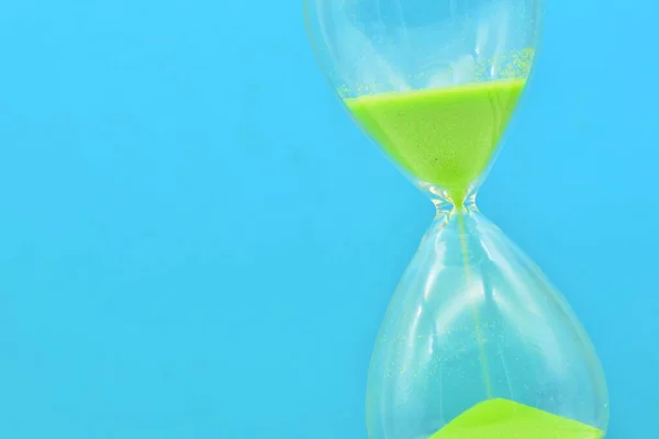 Detail of a green hourglass telling the time