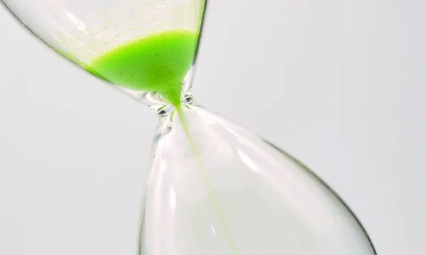 Detail of a green hourglass telling the time