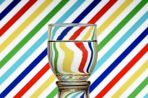 Optical illusion created by the refraction of light and a glass of water