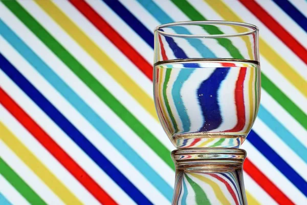 Optical illusion created by the refraction of light and a glass of water