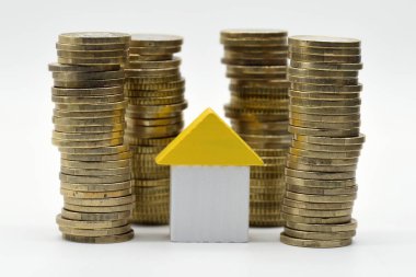 Avro para yığınlarıyla çevrili küçük ahşap ev.