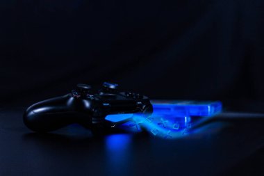 Mando de videojuegos con estela azul sobre fondo negro