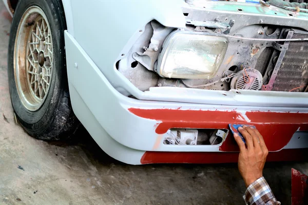 Автомеханик готовит передний бампер автомобиля для покраски — стоковое фото