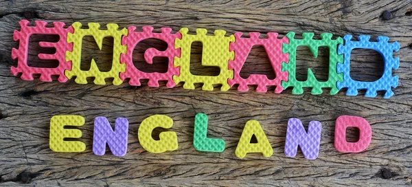 Jigsaw written England word on wood background — Stock Photo, Image