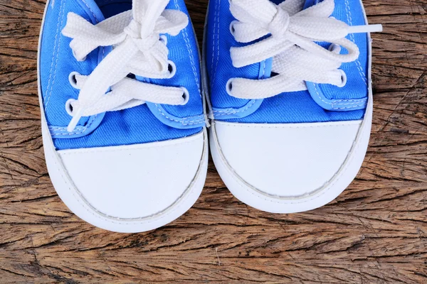 Baby sneakers på trä bakgrund — Stockfoto