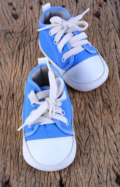 Baby sneakers på trä bakgrund — Stockfoto