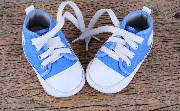 Zapatillas de bebé sobre fondo de madera —  Fotos de Stock