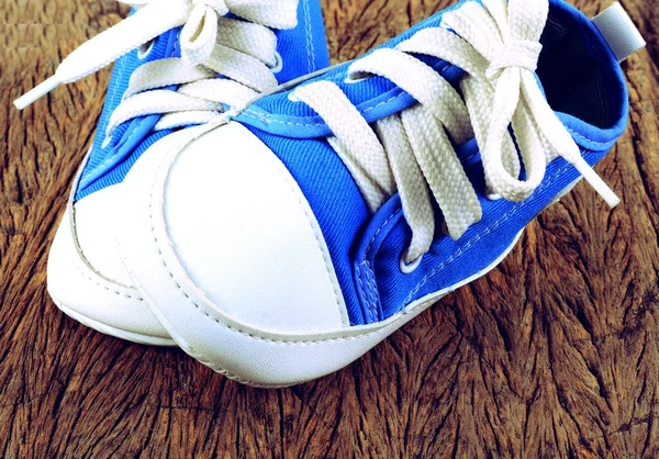 Baby sneakers på trä bakgrund — Stockfoto