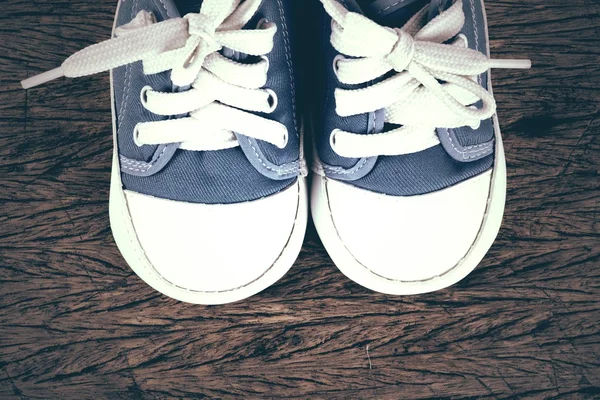 Baby sneakers på trä bakgrund — Stockfoto