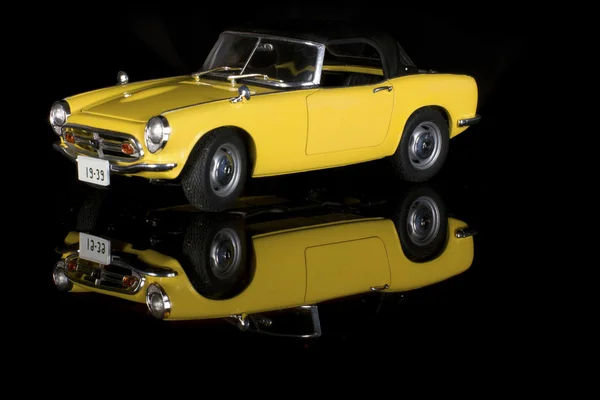 Passenger car convertible bright yellow, model on a black background — Stock Photo, Image